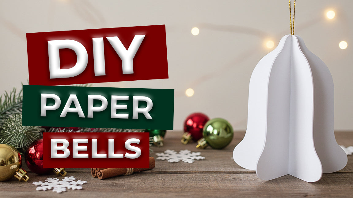 A thumbnail for a DIY Paper Bells tutorial showing a white 3D paper bell ornament on a rustic table.
