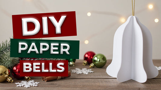 A thumbnail for a DIY Paper Bells tutorial showing a white 3D paper bell ornament on a rustic table.
