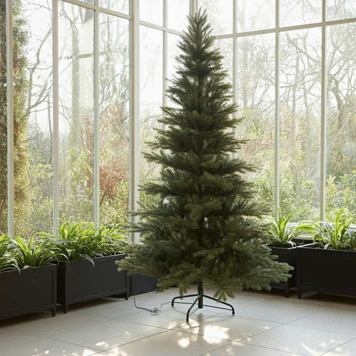 A realistic, premium unlit Christmas tree standing in a bright, beautiful sunroom with large windows.