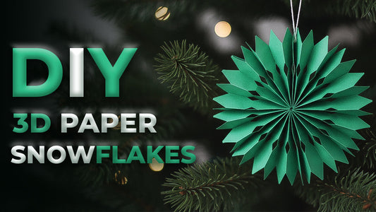 A green 3D paper snowflake ornament hanging on a Christmas tree for a DIY holiday craft tutorial.