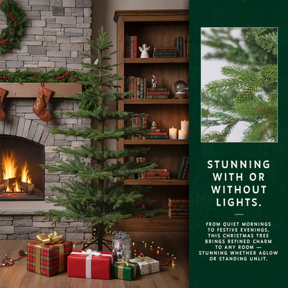 An unlit 9ft skinny Christmas tree by a fireplace, with an insert showing a close-up of the needles.