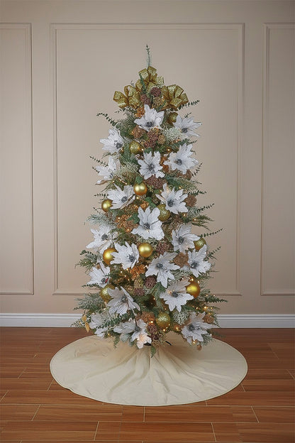 A decorated cypress Christmas tree with large white poinsettias, gold ornaments, and a festive bow topper.