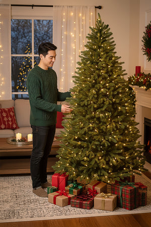 Man smiling while shaping the realistic branches of a 6ft prelit slim christmas tree.